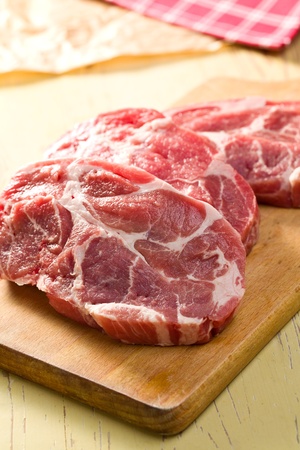 grilled pork: raw juicy meat on wooden table