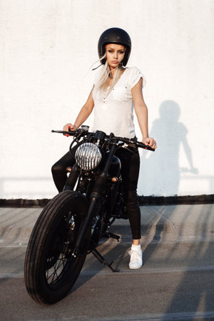 セクシーなファッション女性バイカーの女の子 ビンテージ カスタムのバイクに座っている女性 アウトドア ライフ スタイルの肖像画 の写真素材 画像素材 Image