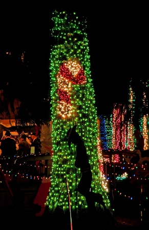 stock photo this vertical holiday stock image has red and white striped candy cane against green christmas lights on a tree with a cowboy cutout image in - Red White Green Christmas Lights stock photo this vertical holiday stock image has red and white striped candy cane against green christmas lights on a tree with a cowboy cutout image in - Red White Green Christmas Lights