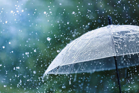Parapluie transparent sous la pluie contre les gouttes d'eau splash background. notion de temps pluvieux.