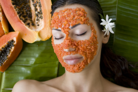 papaya: người phụ nữ xinh đẹp da trắng có đu đủ tươi mặt nạ tự nhiên áp dụng, chăm sóc da và chăm sóc sức khỏe (ngoài trời). vitamin mặt nạ đu đủ lát tại salon spa