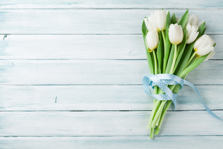 White tulips bouquet on wooden background. Top view with space for your text Фото со стока