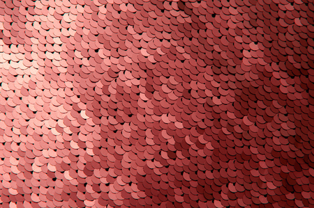 Texture of red color sequins close-up macro abstract background. fashionable expensive fabric with sequins.