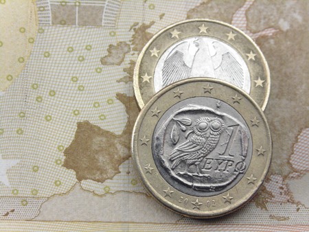 ギリシャとドイツのユーロ硬貨のノートで 50 ユーロ ヨーロッパの地図の上に横たわる ギリシャとドイツのユーロ硬貨のノートで 50 ユーロ ヨーロッパの地図の上に横たわる