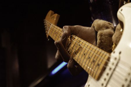 Hand of a left handed guitar player holding a chord