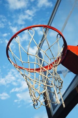 Close up view of a basketball net against th eblue sky