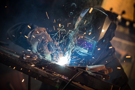 Working welder in action with bright sparks. Фото со стока