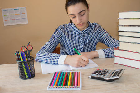 Sad schoolgirl with sitting with stack of books girl studying thoughtful young girl sitting at desk