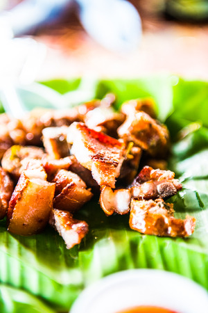 Charcoal boiled pork neck on banana leaf, Thailand. Фото со стока