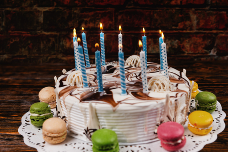 木製の机の上のバースデー ケーキにロウソクを灯して マッチ棒と人間の手 の写真素材 画像素材 Image