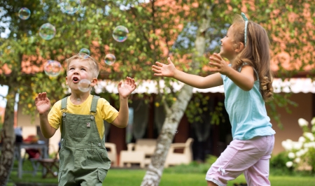 bambini che giocano: Bambini che giocano in giardino estivo Archivio Fotografico