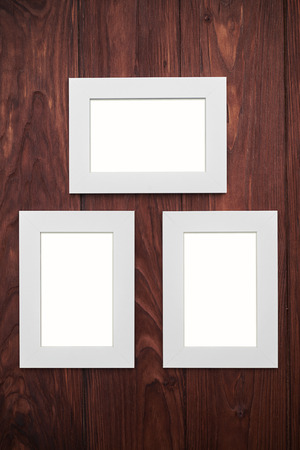 Three Empty Beige Frames 2 Vertical 1 Horizontal On Brown Wood