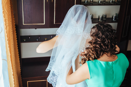 花嫁は準備ができています 髪型と明るい化粧白結婚式で美しい花嫁のドレスします 新郎を待っている幸せなセクシーな女の子 ブライダル ドレスのロマンチックな女性結婚式のための最終的な準備があります の写真素材 画像素材 Image