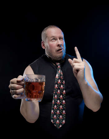 Comic actor man in cap with braids with a glass of beer on a black background, in anticipation of Christmas and New Year
