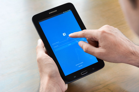 logo samsung: Bangkok, Thailand - May 20, 2015 : a man using Fackbook application, log in page, on Samsung Galaxy Tab3 tablet