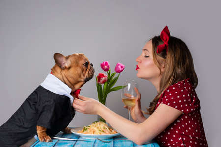 Young girl on romantic valentine's day date with her dog french bulldog Фото со стока