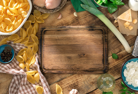 Empty Kitchen Board With Ingredients For Cooking A Delicious Pasta On Wooden Table Top Empty Kitchen Board With Ingredients For Cooking A Delicious Pasta On Wooden Table Top