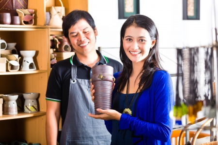 アジア販売やお土産販売店のショップでインドネシア顧客と話す彼女の陶器を示しています の写真素材 画像素材 Image アジア販売やお土産販売店のショップでインドネシア顧客と話す彼女の陶器を示しています の写真素材 画像素材 Image