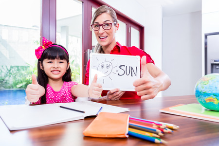 Teacher giving English language lessons to Chinese child