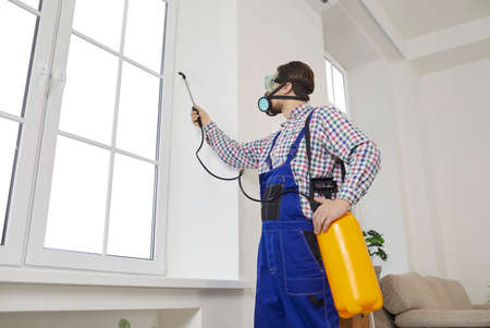 Male Worker With Chemicals Disinfect Client Home From Insecticide. Man Specialist From Pest Control Service Spray Liquid Protect Customer House From Cockroach Or Insect. Maintenance Concept.