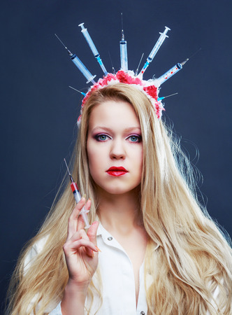 halloween costume of a crazy nurse with crown made of syringes and a syringe in the
