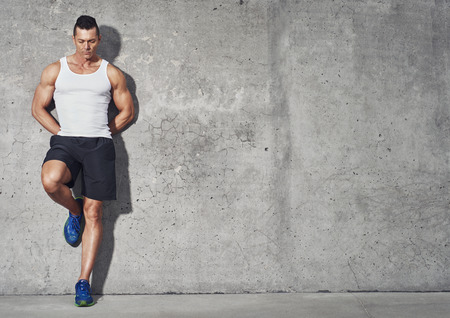 Fit and healthy man, muscular build portrait, fitness concept with copy space on grey background Фото со стока