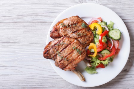 grilled pork: Thịt lợn nướng với salad rau tươi trên một đĩa trắng. một quang cảnh của một ngang