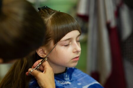 Hairdresser Making A Hair Style To Cute Little Girl The Girl