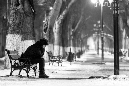 sad lonely: Sad woman sitting on a bench in winter time.