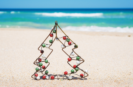 small metal christmas tree with jingle bells on the beach new year and christmas holiday - Small Metal Christmas Tree small metal christmas tree with jingle bells on the beach new year and christmas holiday - Small Metal Christmas Tree