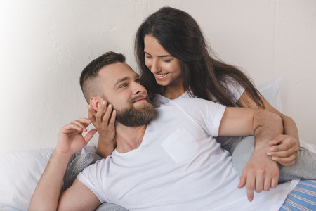 彼氏と彼女を受け入れる笑みを浮かべて 自宅のベッドに横になっています の写真素材 画像素材 Image