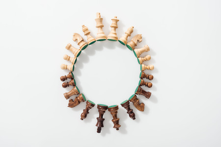 Top view of round frame made of wooden chess figures on white background Stock Photo