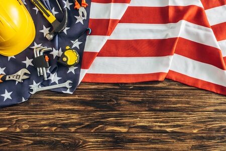 Top view of instruments and safety helmet on american flag and wooden surface labor day concept Stock Photo