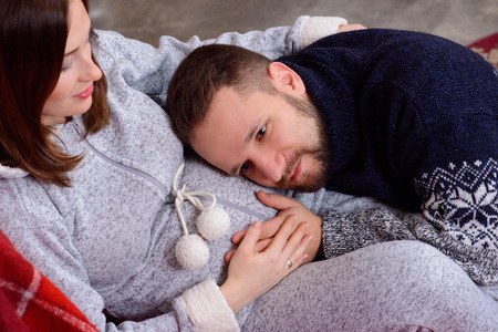 Heureux Mari Ecoute Les Battements De Coeur De Bebe Couche Sur Le Ventre De Sa Femme Enceinte Vetu D Un Pull En Laine Tricote Vue D En Haut L Homme A Ouvert Les Yeux Banque D Images Et Photos Libres De Droits Image