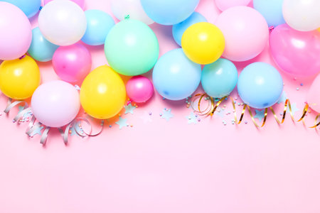 Pastel birthday background with balloons, confetti and streamers, top view