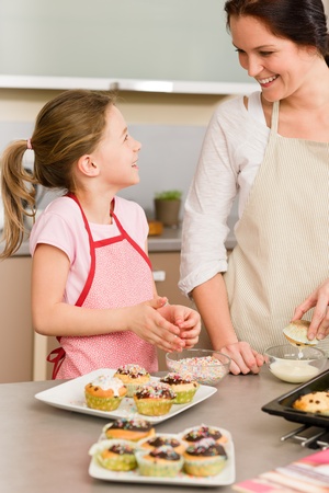 mother and daughter decorating cupcakes sprinkles happy together at home photo - Woman Decorating Cupcakes mother and daughter decorating cupcakes sprinkles happy together at home photo - Woman Decorating Cupcakes
