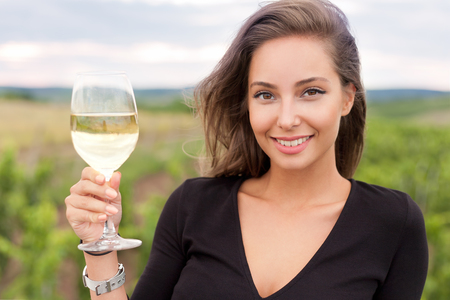 Outdoors portrait of a beautiful wine tasting tourist woman.