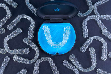 Plastic case with invisible transparent orthodontic retainers invisalign on black background. aligner brackets or braces dental container Zdjęcie Seryjne