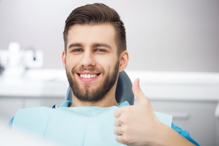 Mi sonrisa es perfecta! Retrato del paciente feliz en silla dental. Foto de archivo - 59456035