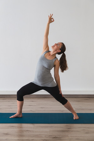 Pregnant woman doing yoga in reverse warrior pose