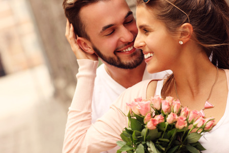 A picture of a young romantic couple with flowers in the city Фото со стока
