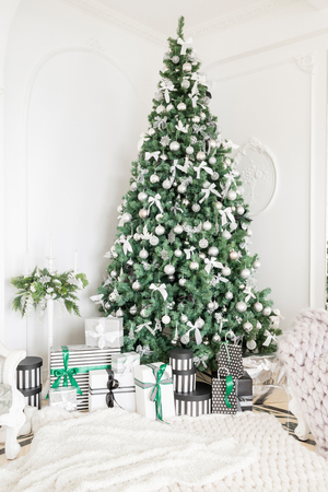 Luxury apartment decorated for christmas. xmas tree with presents underneath in living room