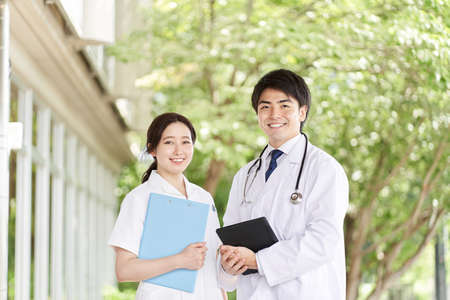 Doctors and nurses standing with a smile on a green background