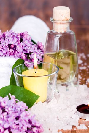 полотенце: bath and spa items (towel, salt, oil, lilac, candle) on wooden background