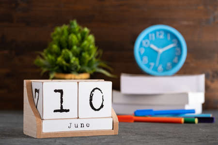 June 10th june 10 wooden cube calendar with blur objects on background Фото со стока June 10th june 10 wooden cube calendar with blur objects on background Фото со стока