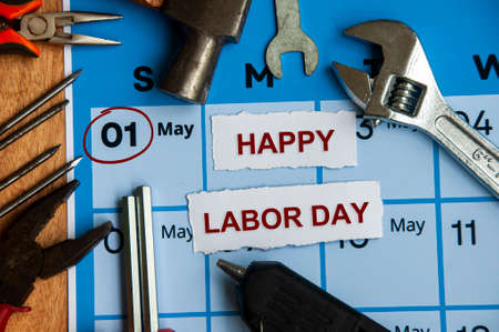 Top view of happy labor day text on torn paper with calendar and working tools background copy space and labor day concept