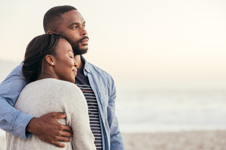 Smiling young African couple enjoying a sunset at the beach Stock Photo - 90816526
