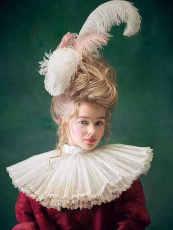 Młoda i piękna kobieta jako marie antoinette na ciemnozielonym tle. styl retro, porównanie koncepcji epok. piękna modelka o klasycznym historycznym charakterze, staromodna. Zdjęcie Seryjne
