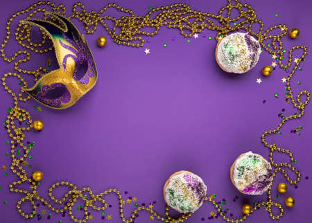 Mardi Gras King Cake Sufganiyot Donuts, Masquerade Festival Carnival Mask, Gold Beads And Golden, Green, Purple Confetti On Purple Background. Holiday Party Invitation, Greeting Card Concept. Top View