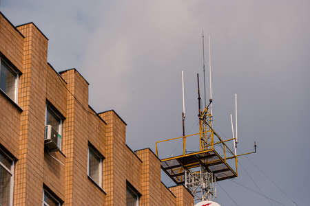 GSM transmitters on a roof of administrative building. Mobile antenna in a building, against gray sky
